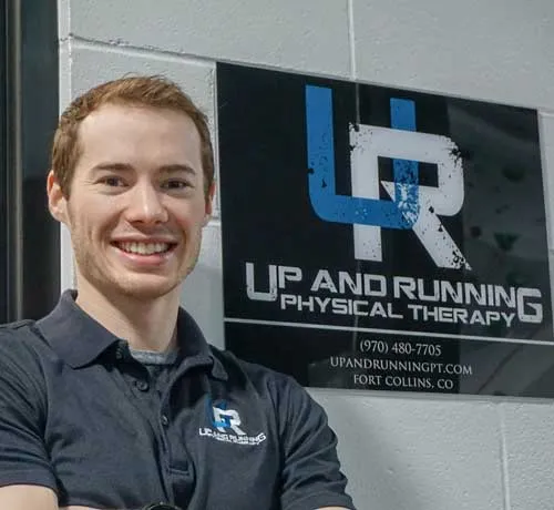 a man standing in front of a sign that says up and running physical therapy.