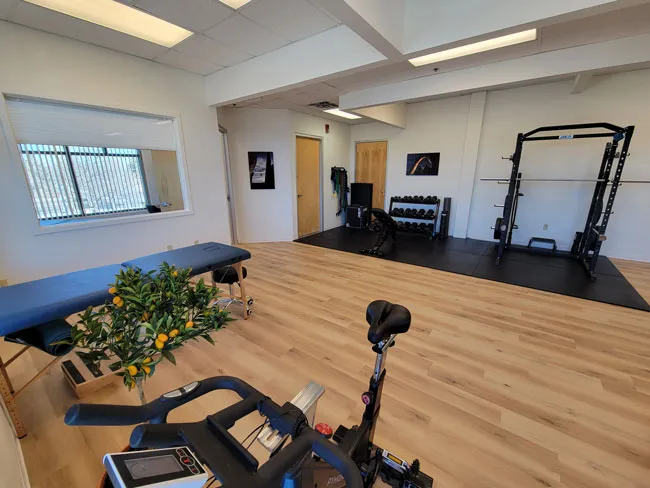 a home gym with exercise equipment and a yoga mat.