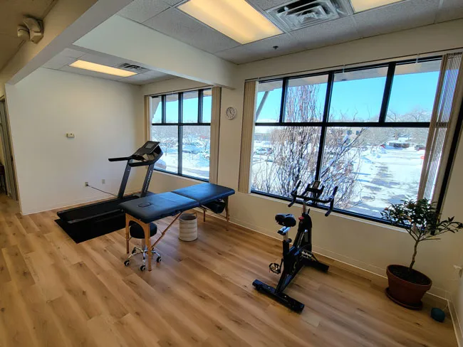 a home gym with a treadmill and exercise equipment.