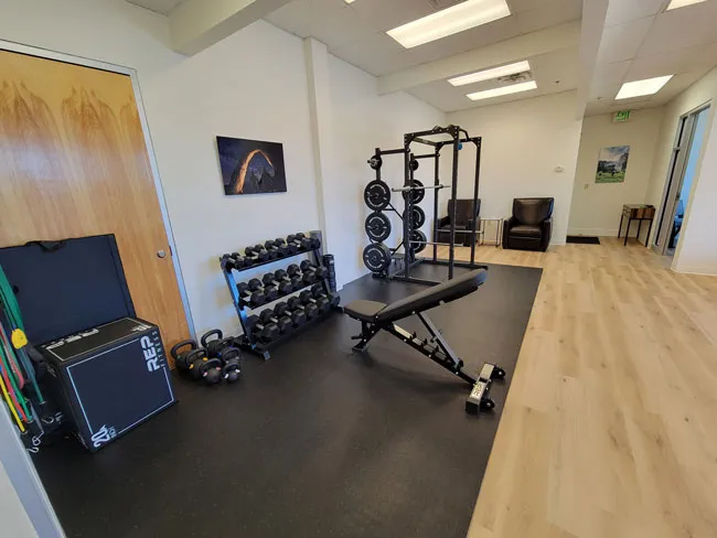 a room with a gym equipment and a hard wood floor.